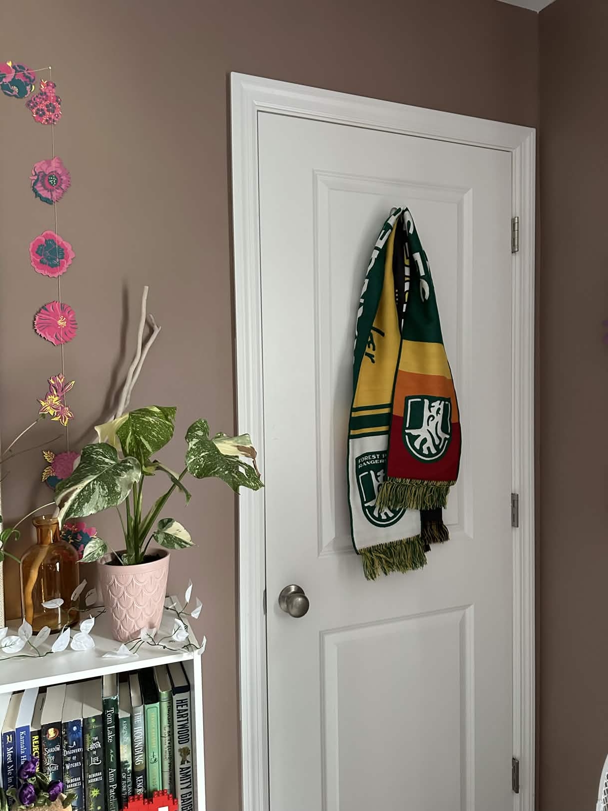 A Founding Member scarf hung on the back of a door.